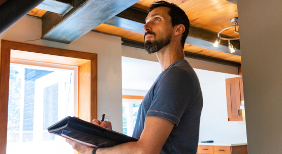 Man taking notes on a tablet while conducting an assessment.