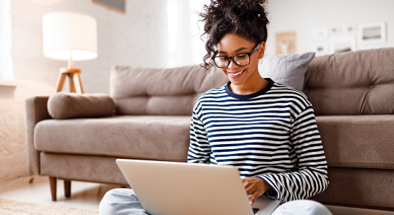 Woman sitting on the floor working on a laptop