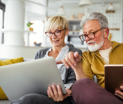 Man and woman looking at a laptop and phone
